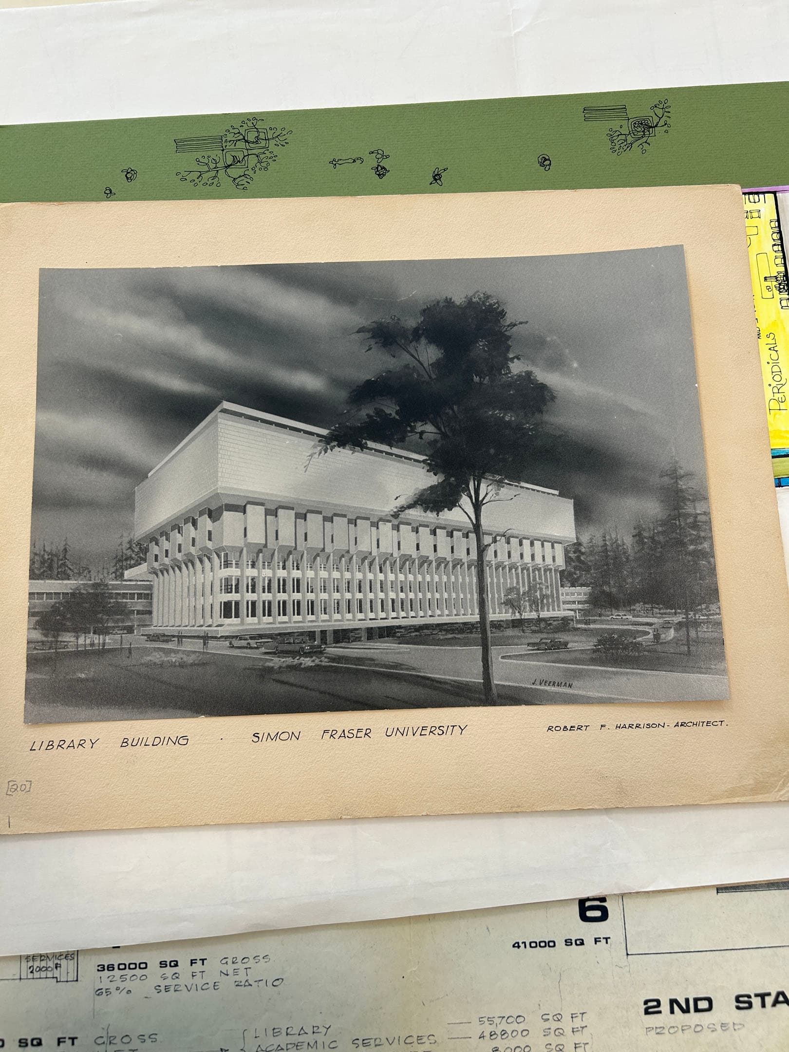 Black and white architectural rendering of the Library Building at Simon Fraser University, designed by architect Robert F. Harrison. The building features a distinctive modernist style with a wide, elevated structure supported by numerous columns. Surrounding landscaping elements and a tree are visible in the foreground, with a cloudy sky in the background. The image is mounted on a beige page with handwritten text at the bottom.