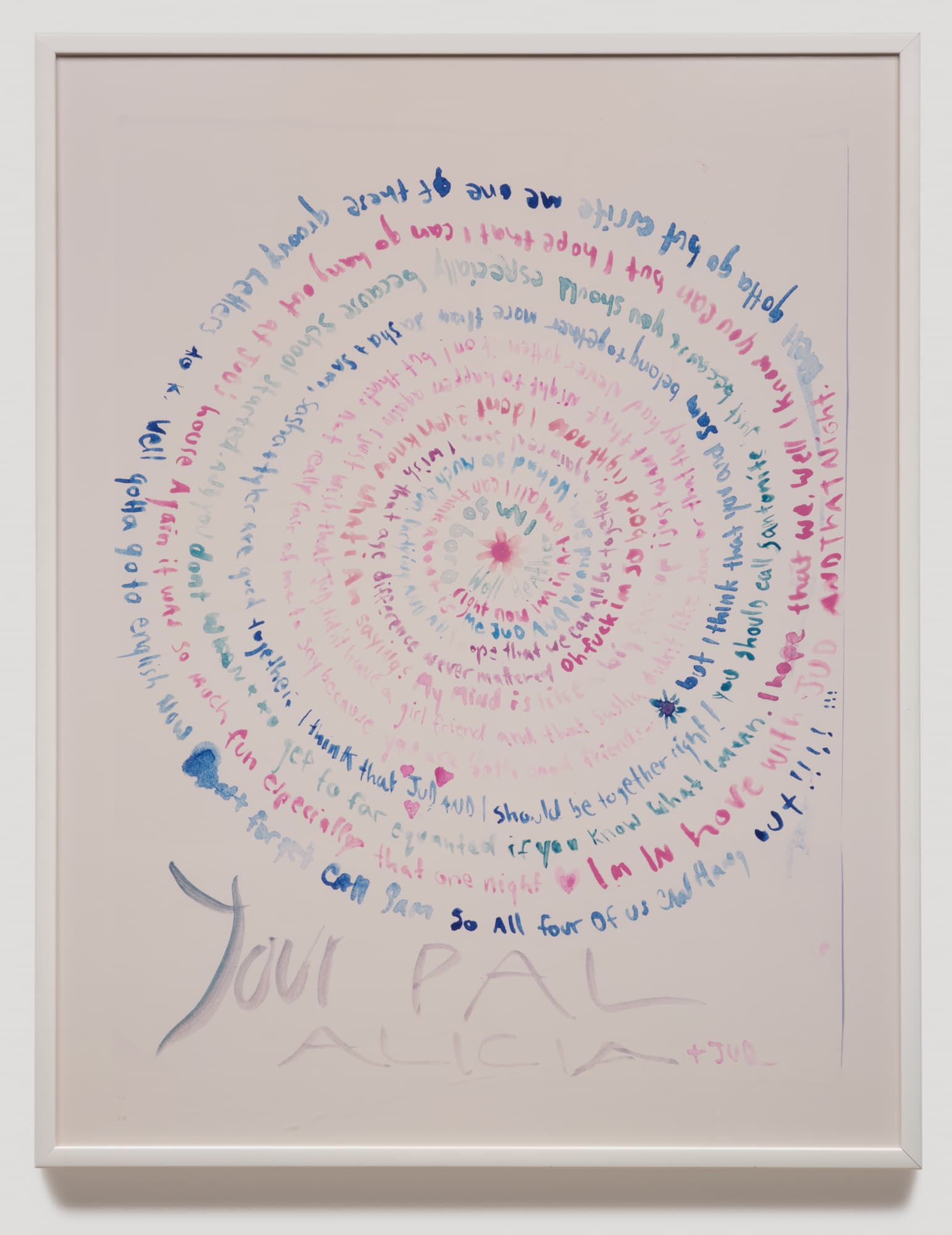 A circular text design features handwritten messages in various colors, primarily blue and pink, swirling inward. The text expresses thoughts and feelings from one person to another, with phrases and words appearing in a spiral pattern. At the bottom, "Your Pal Alicia + Jun" is written in larger letters. The background is a soft, light hue, enhancing the colorful text. The artwork is framed in a simple white frame.