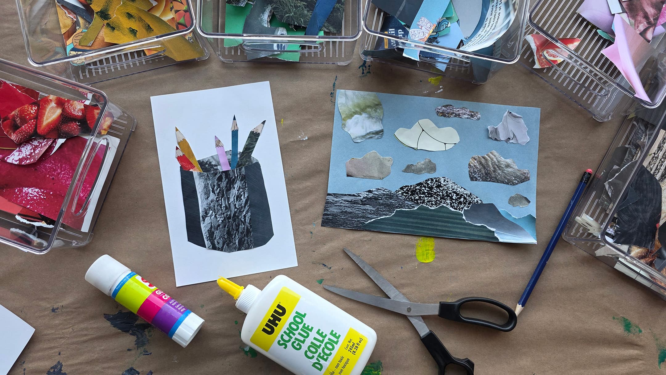 A flat lay of a crafting workspace featuring two collages: one depicts colored pencils in a container and the other shows cut-out cloud shapes on a blue background. Surrounding the collages are containers filled with colorful paper scraps, a bottle of school glue, a pair of scissors, and a pencil, all set on a brown paper surface.